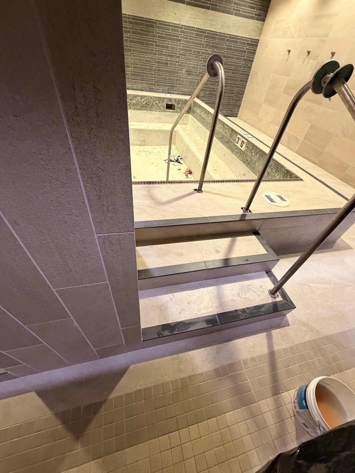 Tiled shower with contrasting decorative bands and grab bars
